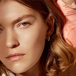 Model Arizona Muse holding bottle of shampoo.